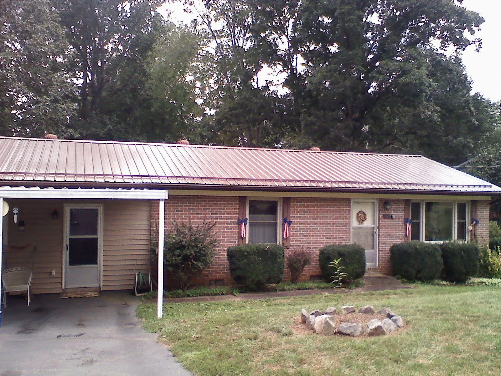 Bronze metal roof and carport on a brick ranch home — Roof Repair work by our crew in Kings Mountain