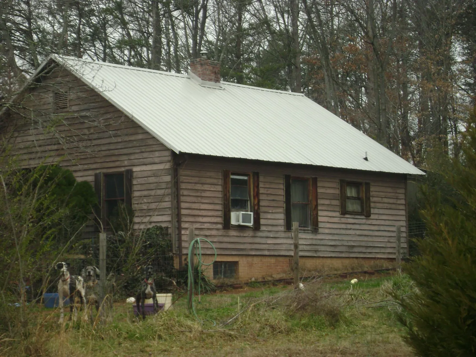 White metal roof on an old wood sided farmhouse, from a Metal Roof Installation job in Kings Mountain